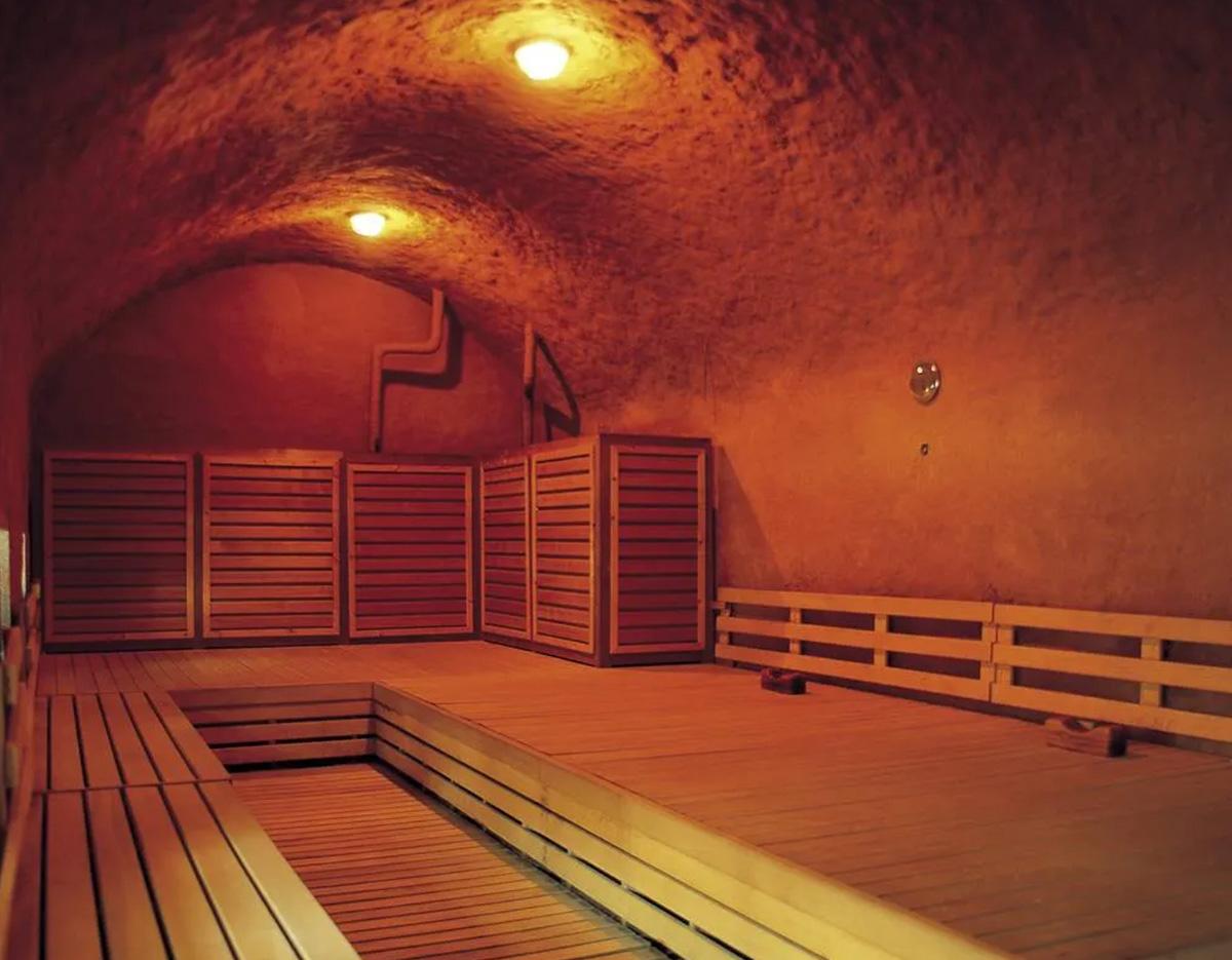 K-beauty 빛의 공식: 케데헌 에디션 서울 원데이 투어 wooden sauna room with tiered benches, curved stucco ceiling and warm amber lighting
