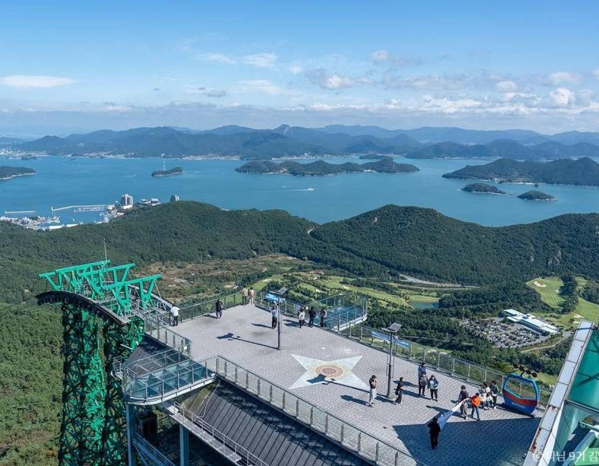 Observation deck at KTO 고성 만화방초 수국 축제 & 통영 tour overlooking islands, blue sea, and green mountainous coastline