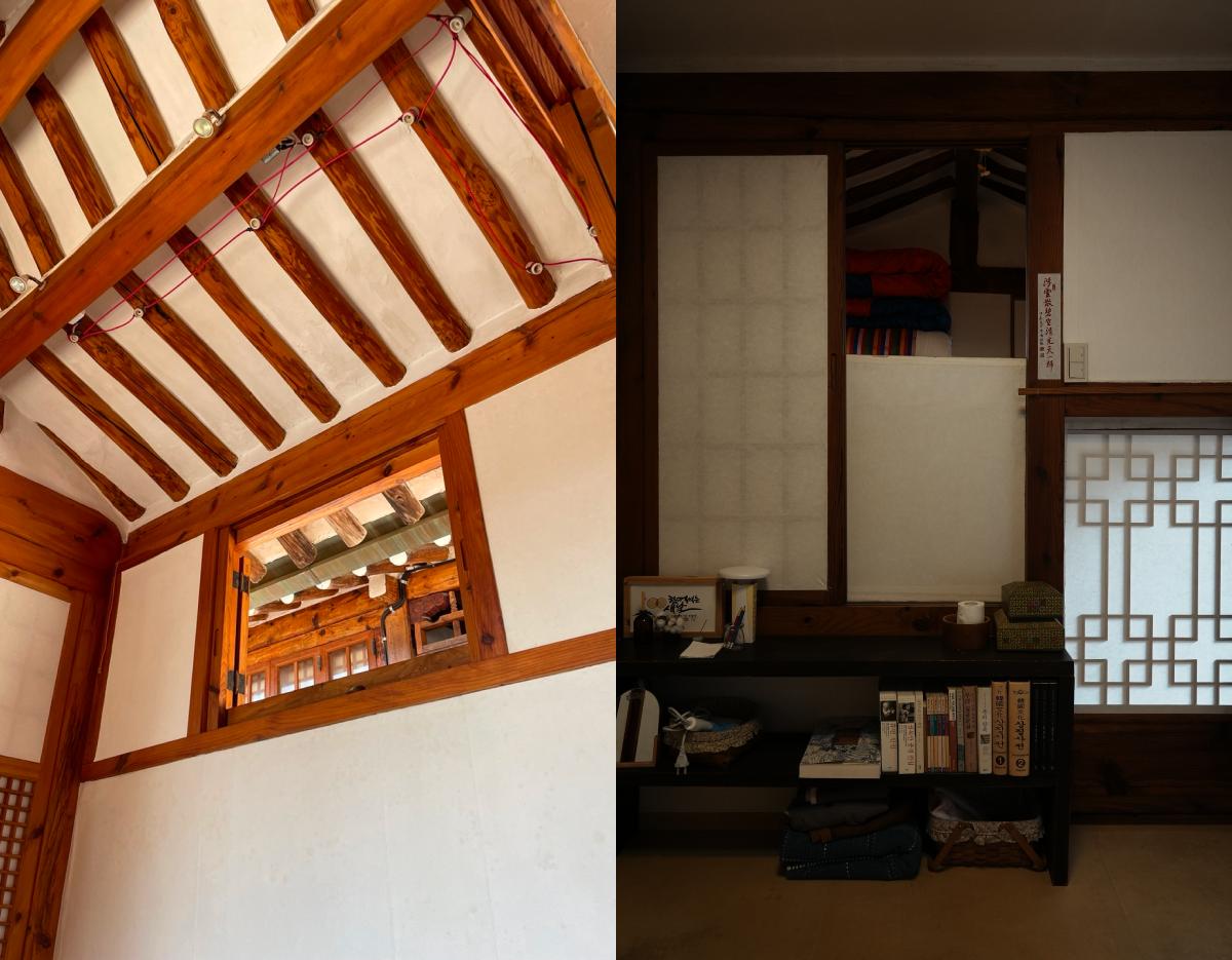 Traditional Korean hanok interior showing wooden ceiling beams, small loft window, bookshelf with stacked books and folded bedding