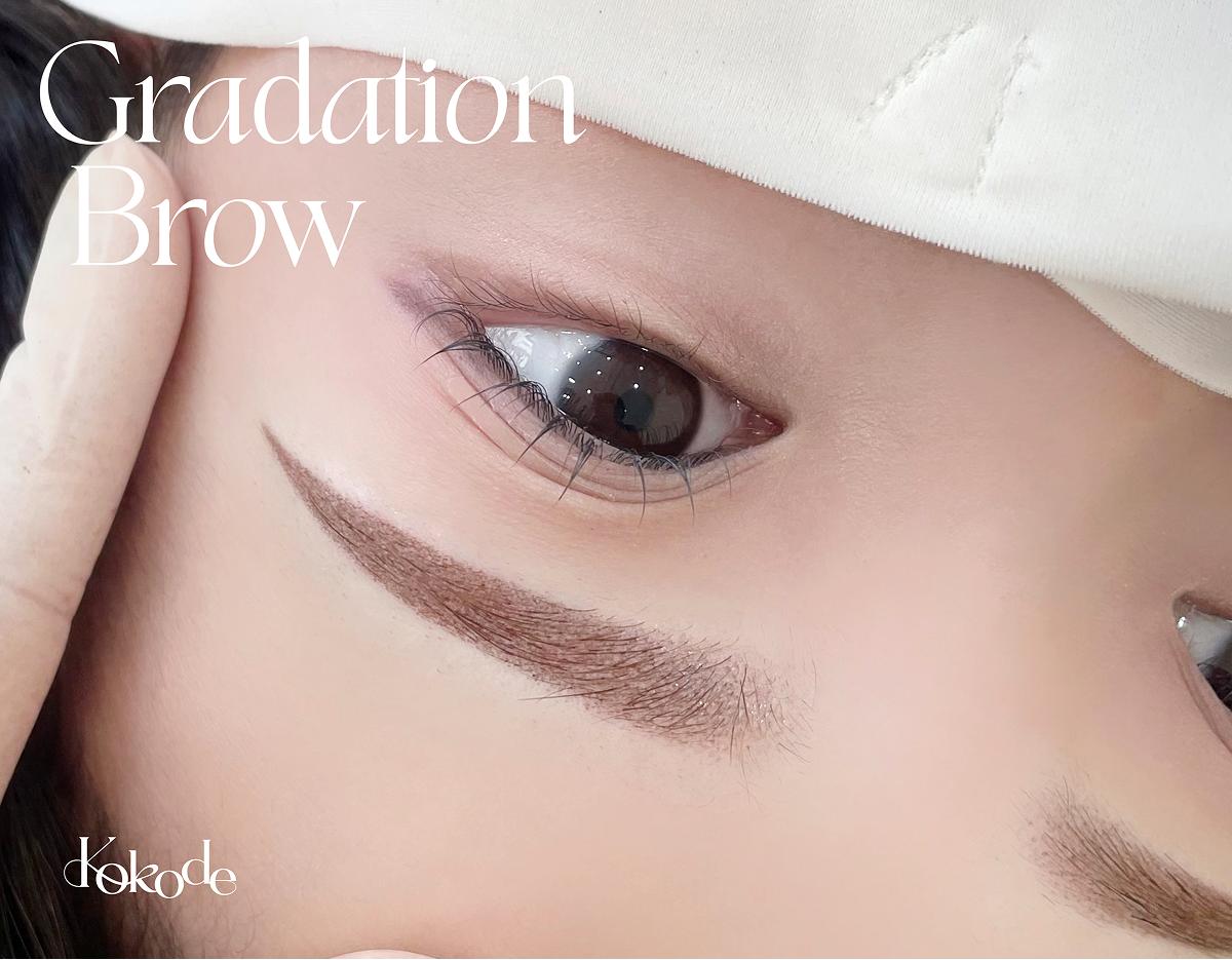 close-up of a client's eye area showing freshly done brown gradation brow tattoo with soft dot shading, Kokode signage