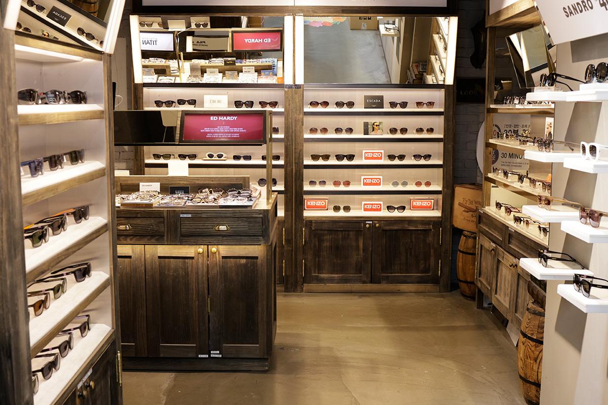 Interior of Look Optical Gangnam store with wooden display cabinets and shelves filled with sunglasses and eyewear frames