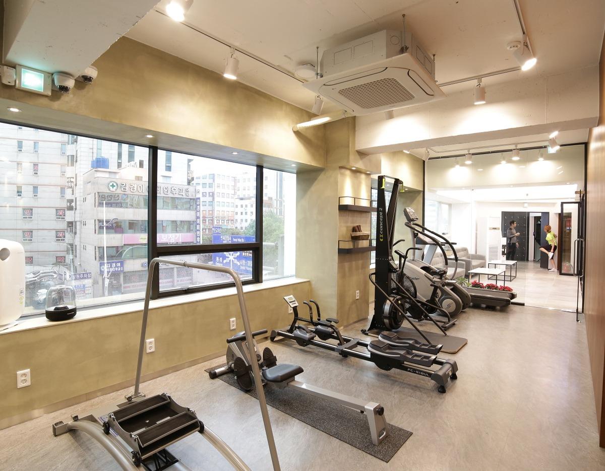 Jayeonan-e Han Clinic Yeonsan | USP interior gym area with rows of cardio and rowing machines by large windows