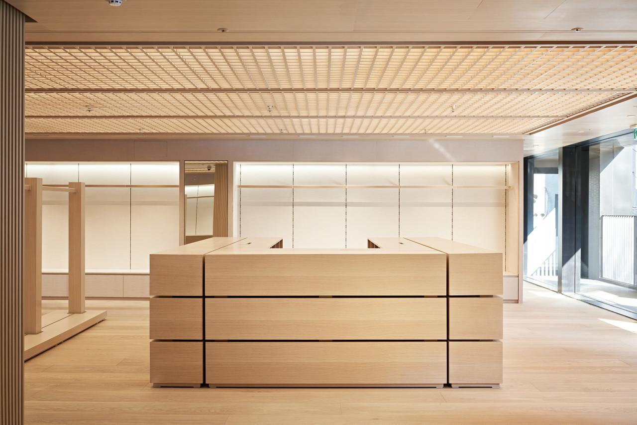 Minimalist Pottery Hannam interior with light wood central counter, open shelving, slatted ceiling and large front windows.