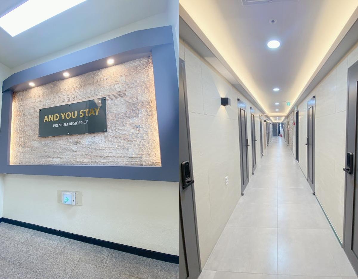 앤유스테이 entrance sign on textured wall and long, well-lit hallway lined with individual room doors and electronic locks