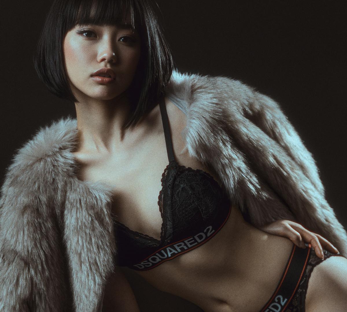 shoulder-length bob hairstyle, model in black lace bralette and matching briefs with DSQUARED2 band, draped in gray faux fur coat