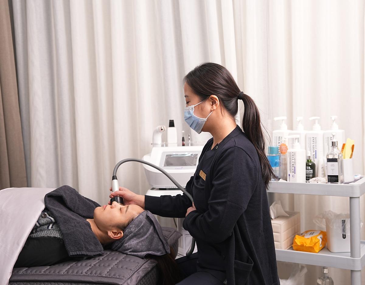 JNB Clinic Sinsa procedure photo: 피부관리 treatment process with medical staff and patient.