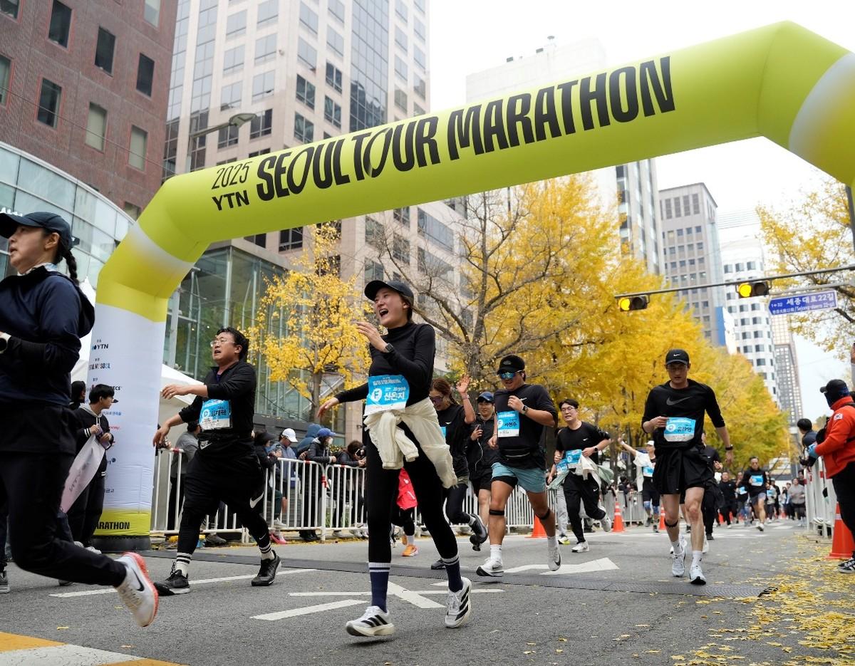 Runners passing under the Seoul Tour Marathon arch in central Seoul