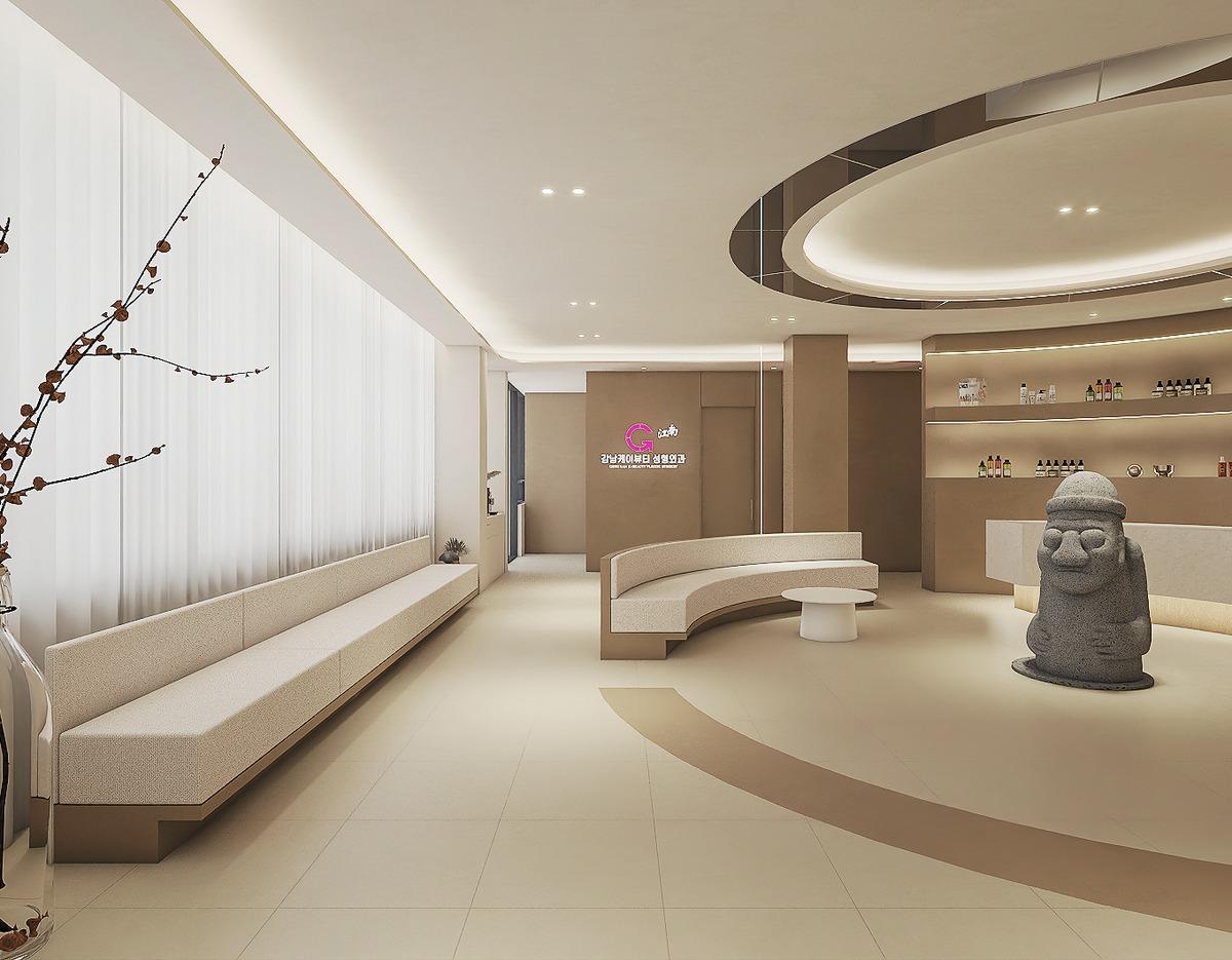 케이뷰티성형외과 제주점 waiting area with curved beige seating, long bench by sheer windows, circular ceiling feature, and Jeju dol hareubang statue