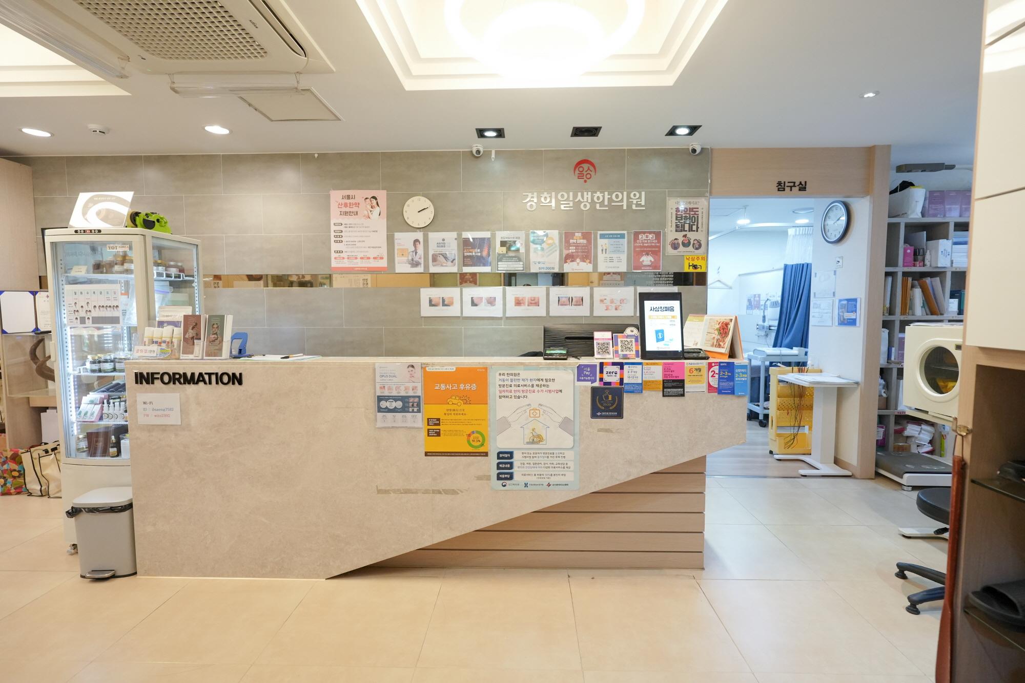 경희일생한의원 reception desk with information counter, brochures, posters on wall and clinical room entrance behind