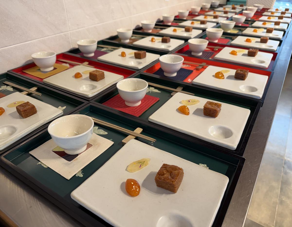 소울트레일 in 금정산: multiple lacquered trays each with a white teacup, small square temple dessert and candied fruit.