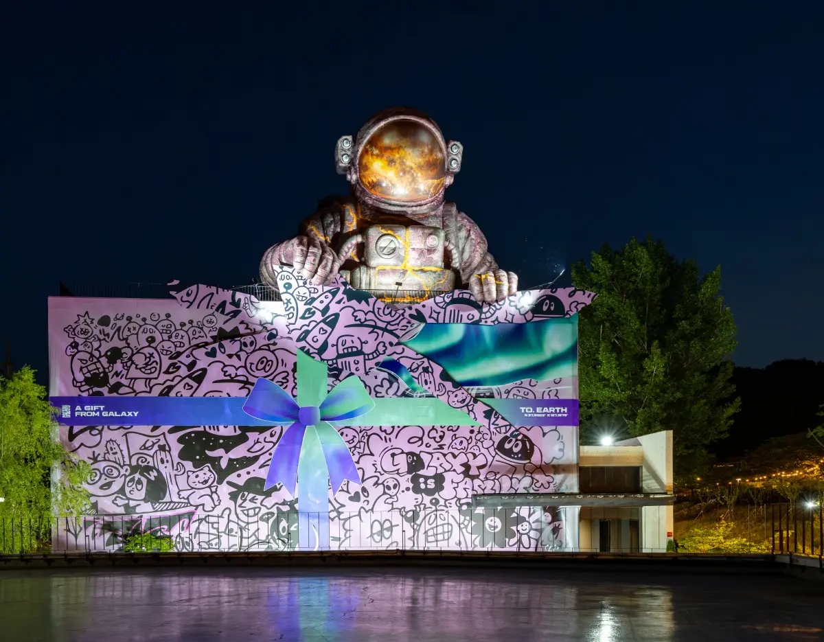Large astronaut installation at Galaxy Robot Park illuminated at night