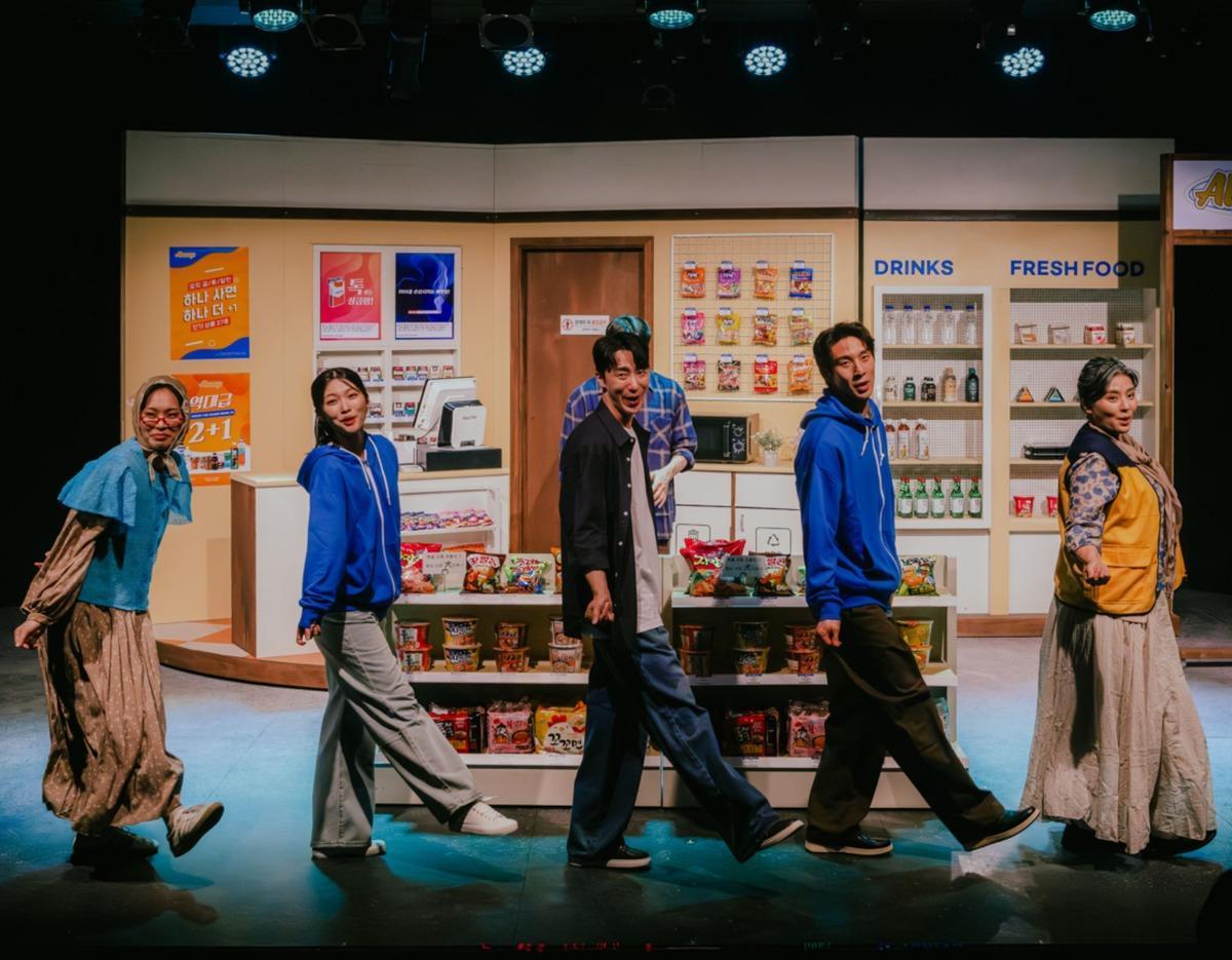 Cast members dancing in front of a convenience store set during the Seoul musical "[서울] 뮤지컬 <디어 에반 핸슨>" performance.