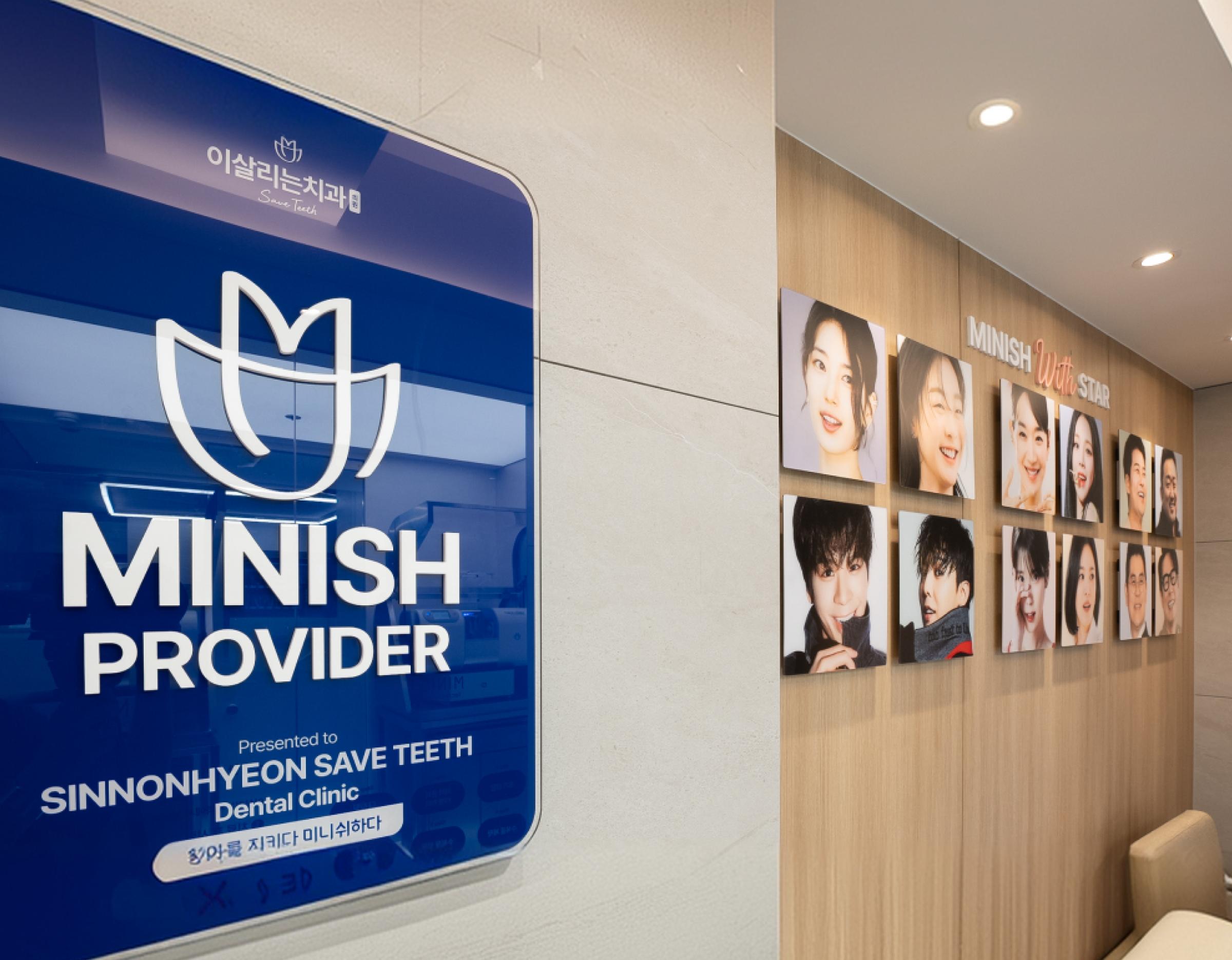 MINISH PROVIDER blue wall plaque with logo beside a wood-paneled gallery of smiling patient and staff portraits at 이살리는치과의원 신논현역