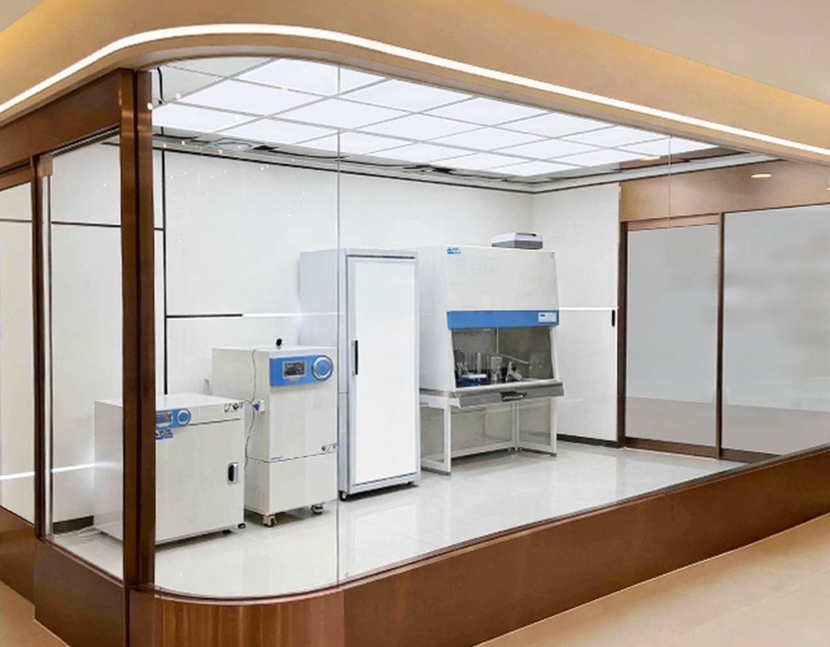 365mc병원 부산점 sterile lab room with white cabinets, refrigeration unit and biosafety hood behind glass wall