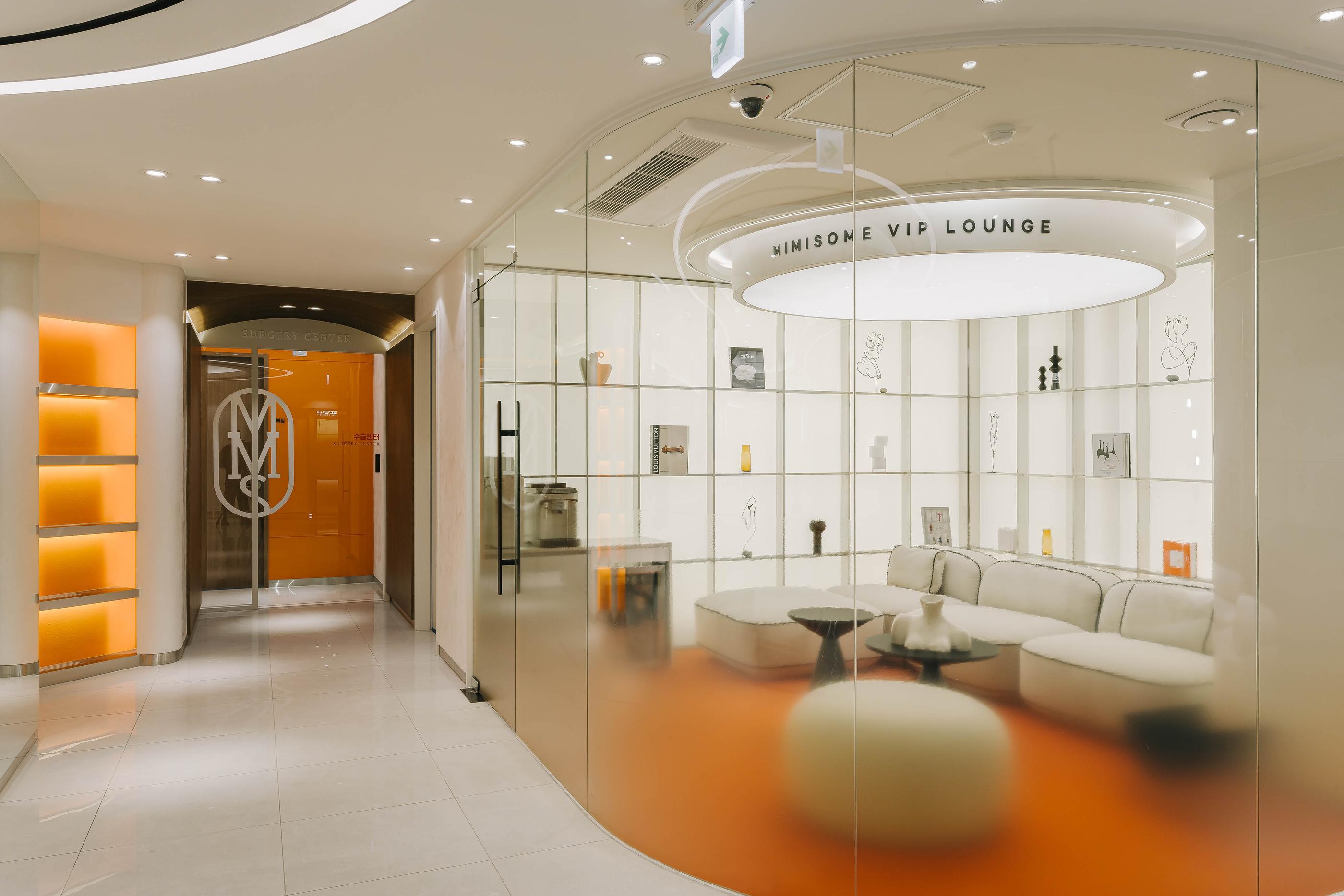 MIMISOME VIP LOUNGE glass-walled waiting area with curved white sofa, round ottomans, orange floor accents and lit display shelves