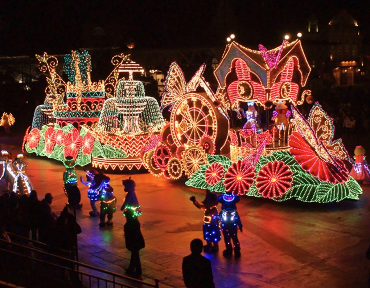 Lotte World nighttime parade floats and performers lit by colorful decorative lights during evening parade at Lotte World adventure