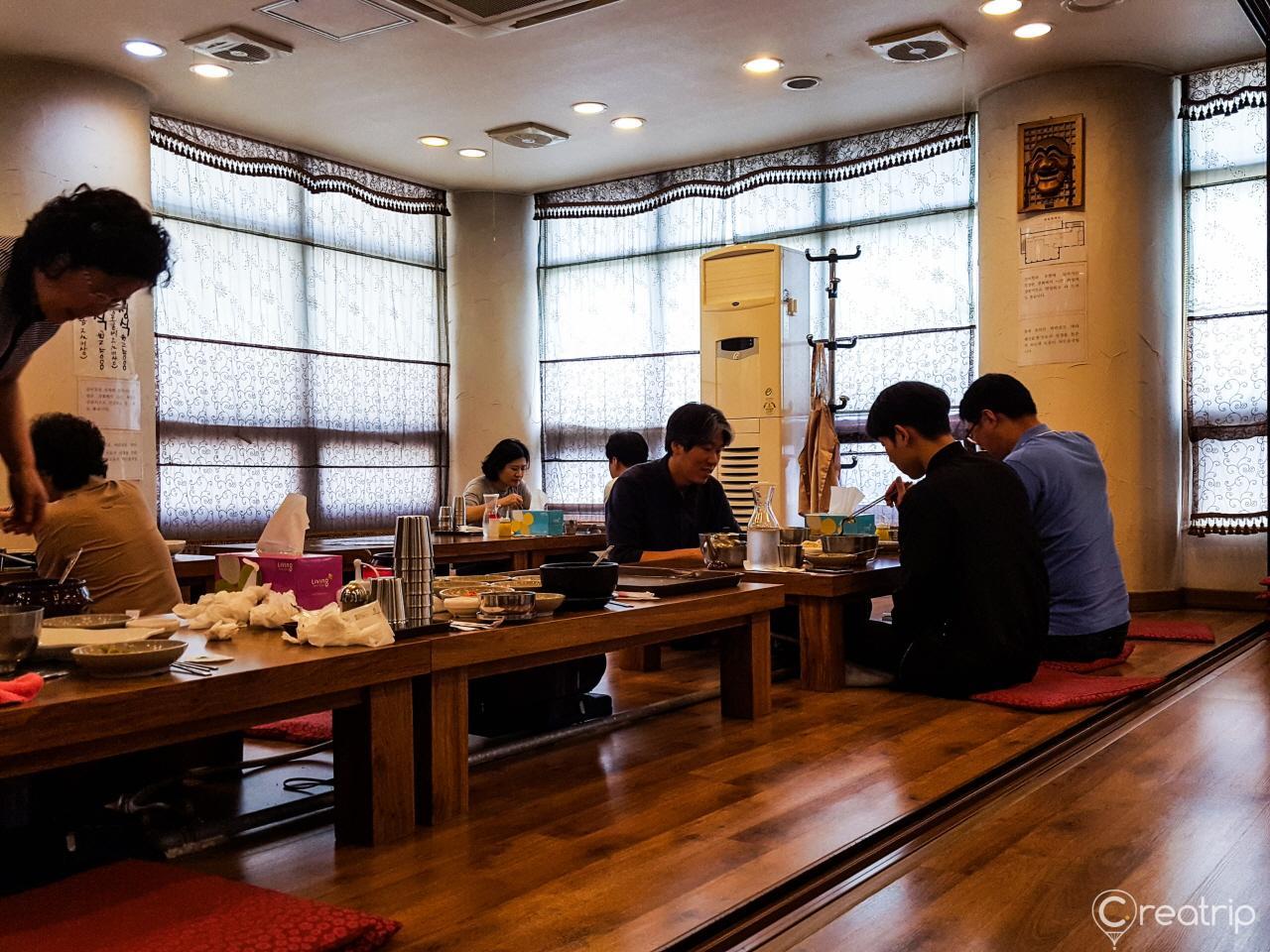 Interior of 함평면옥 restaurant: table, window, and furniture made of hardwood with varnish finish
