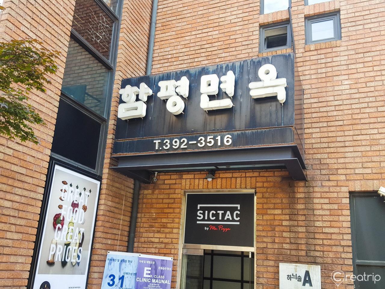 Exterior of 함평면옥 restaurant in Seoul, with brick facade, window signage, and city font fixtures.