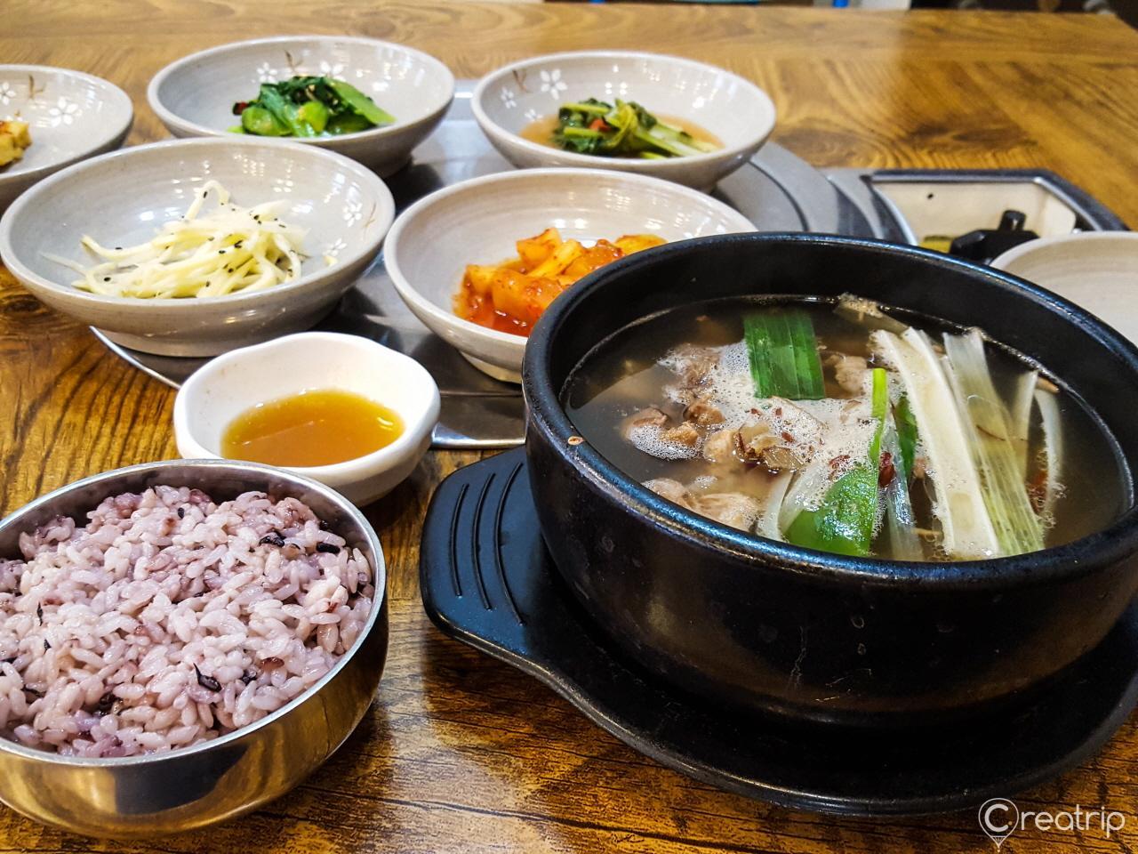 Korean cuisine dish of galbitang (beef rib soup) served in traditional tableware, including a mixing bowl and plate at Hampyeong Menok restaurant.
