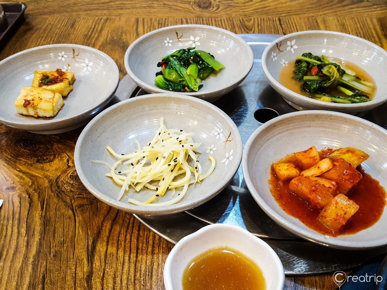 A plate of delicious 밑반찬 from 함평면옥 with fresh produce and traditional tableware.