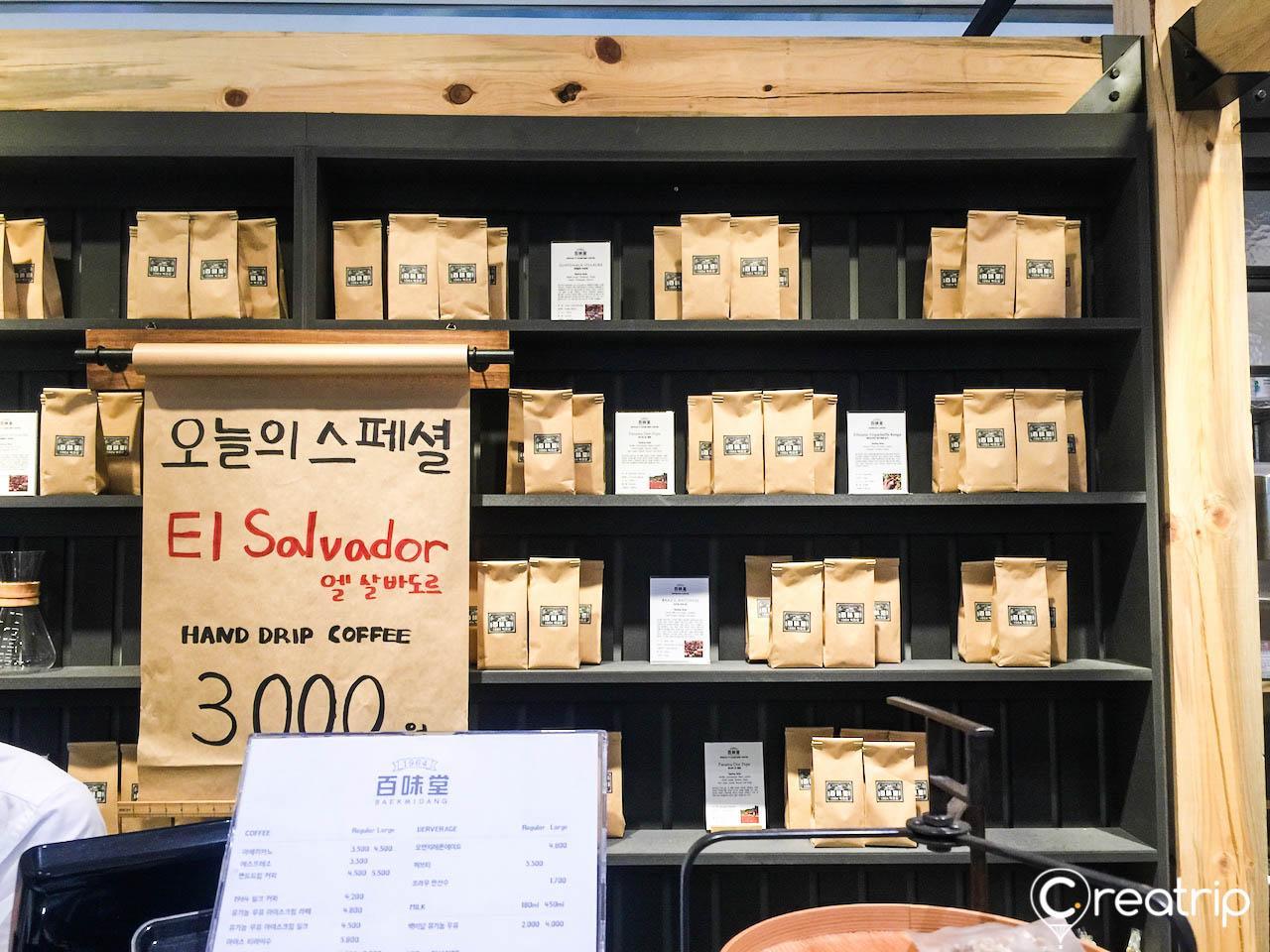 Shelves of hardwood display coffee products in 백미당 영등포 타임스퀘어점, Seoul.