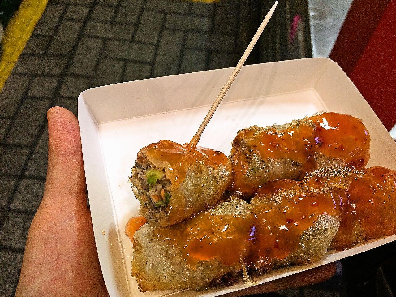 Colorful spread of street food in 부평깡통시장 market, Seoul featuring pinchos, fried dishes, and fresh ingredients.