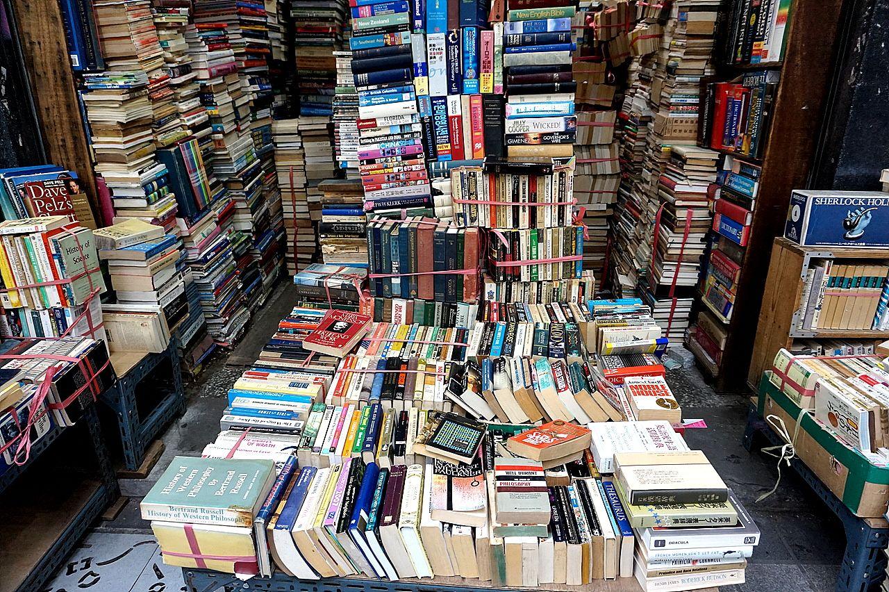 A bustling marketplace in Busan with rows of bookshelves in a charming alleyway.