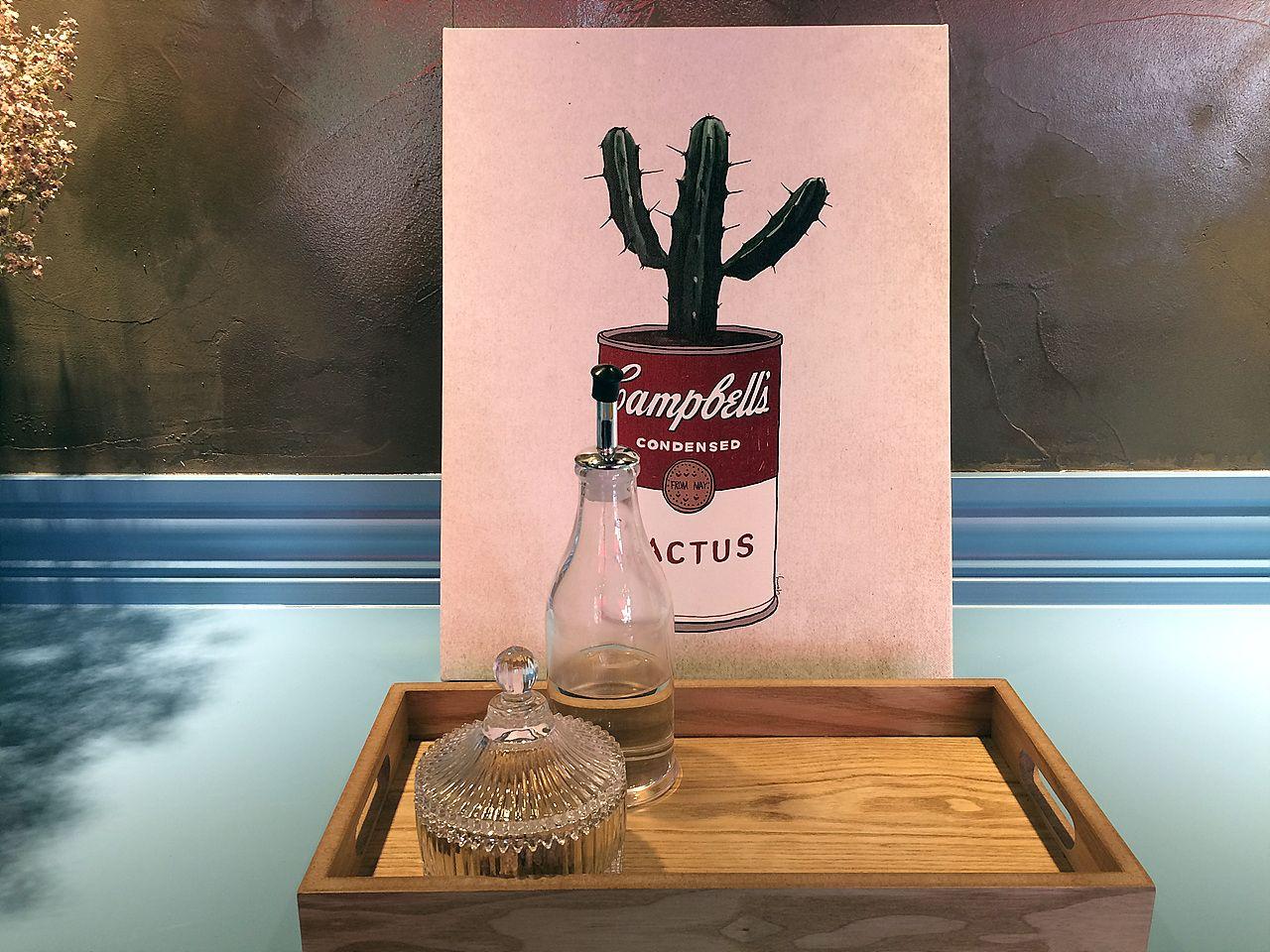 Interior shot of the stylish 카페 유달리 in Seoul featuring wooden tables, hardwood walls, and window lighting. Barware and Korean font add character.