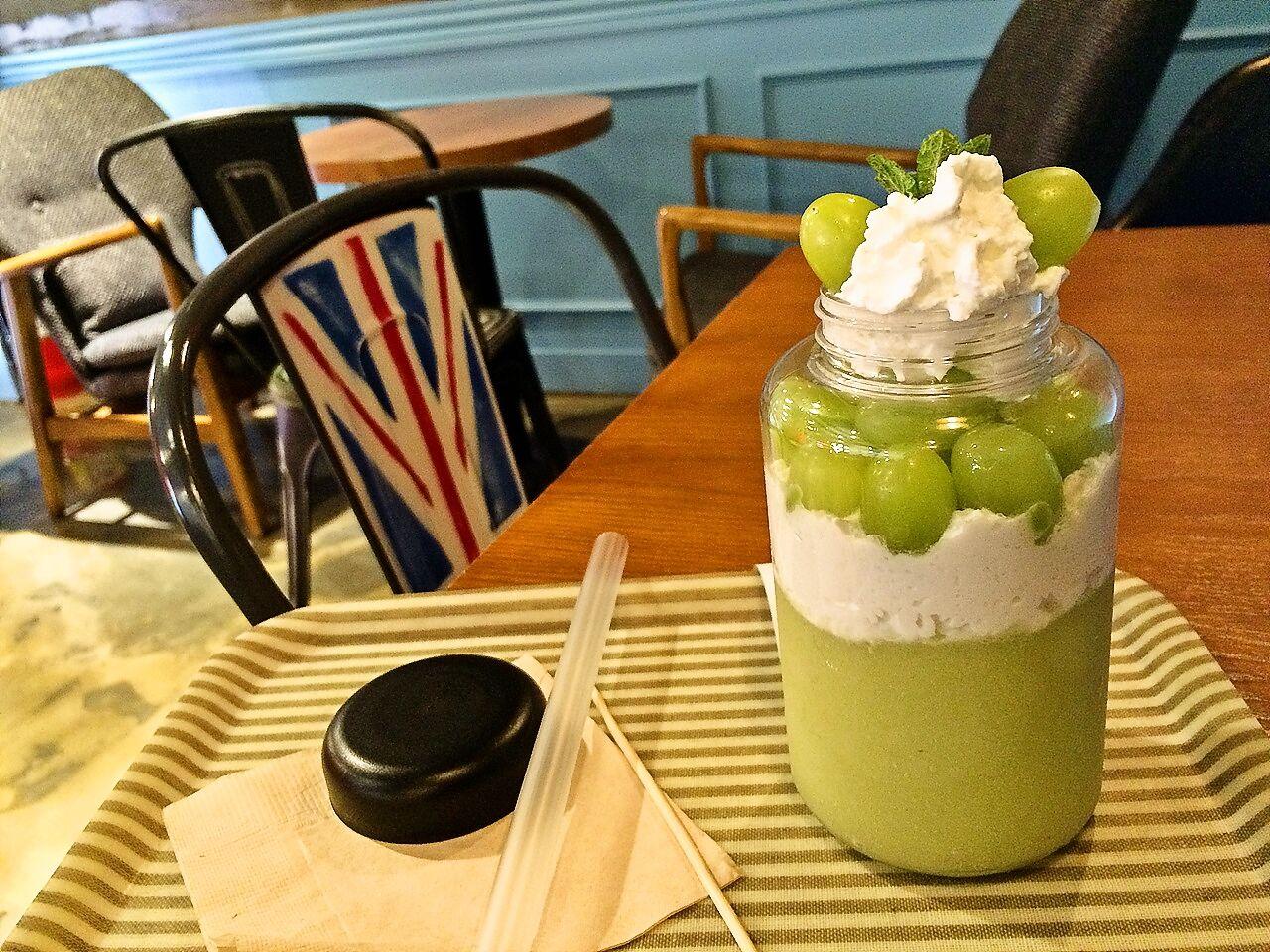 A wood table with 카페 유달리's 메론 음료, food, dishware, and drinkware.