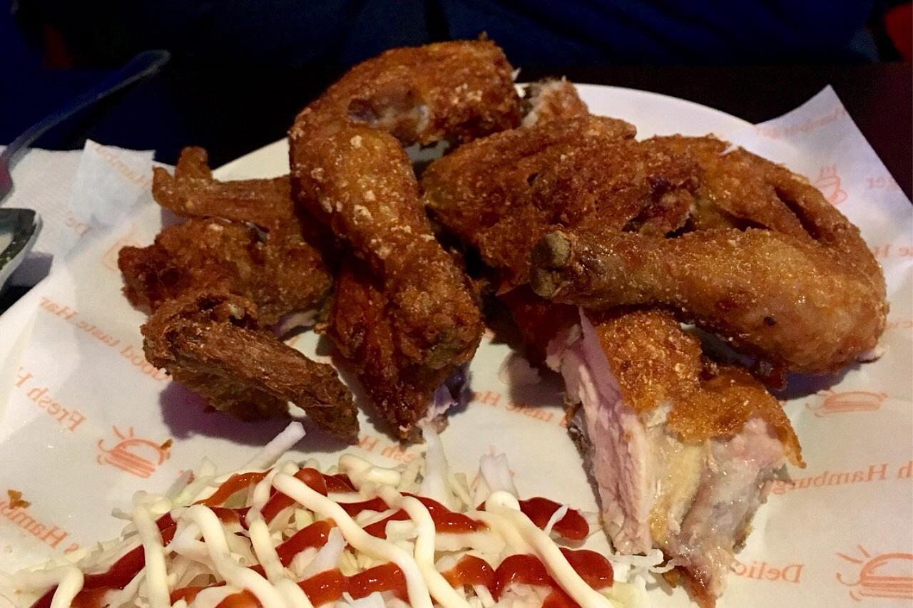 crispy fried chicken hot dogs with delectable toppings on a plate.