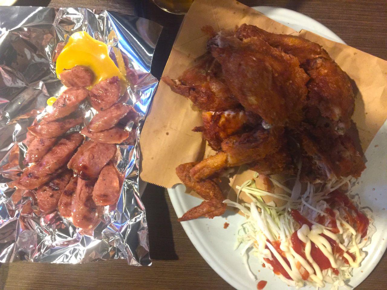 delicious and crispy fast food dish featuring sausage, grilled chicken, and crispy fried ingredients served on a plate with tableware.