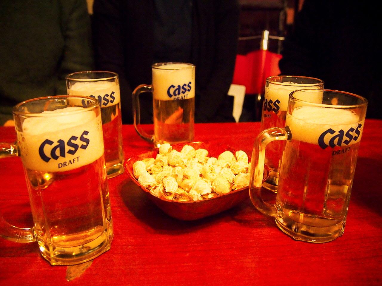 A spread of Brown Chicken Hop's food and drink offerings on a table with barware and beer glasses.