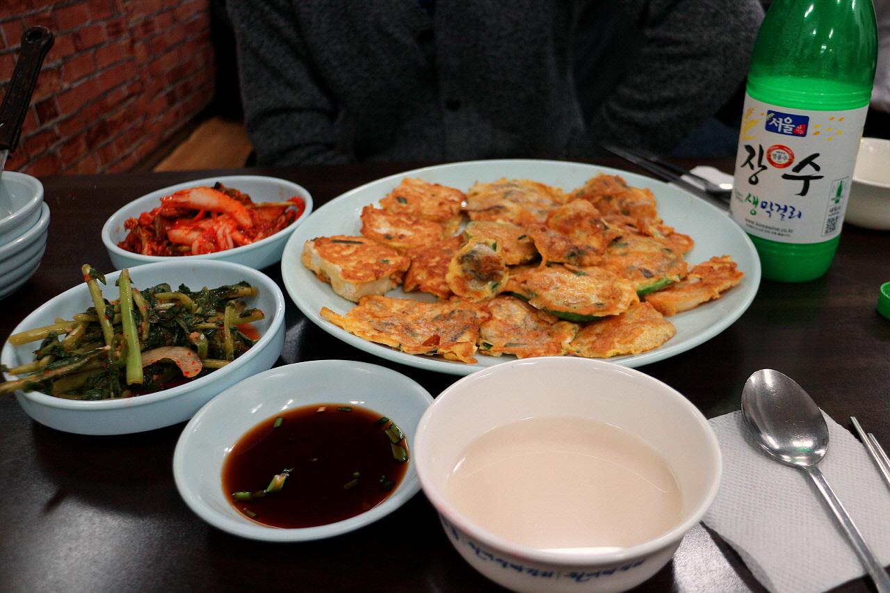 korean seafood dish featuring 'Eulji Sujeobi' noodles, various ingredients, and tableware on a table in Seoul.