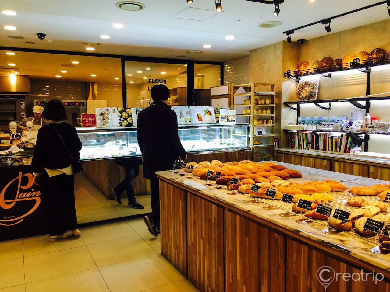 interior of 1898 Plus bakery in Myeongdong Cathedral souvenir mall with natural foods, tableware, and lighting.