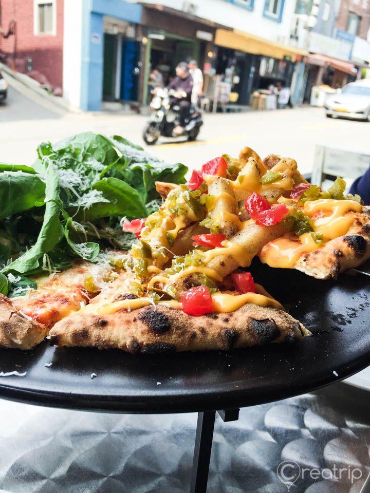 An 8-piece pizza with tableware and ingredients on a plate, served in a Korean restaurant.