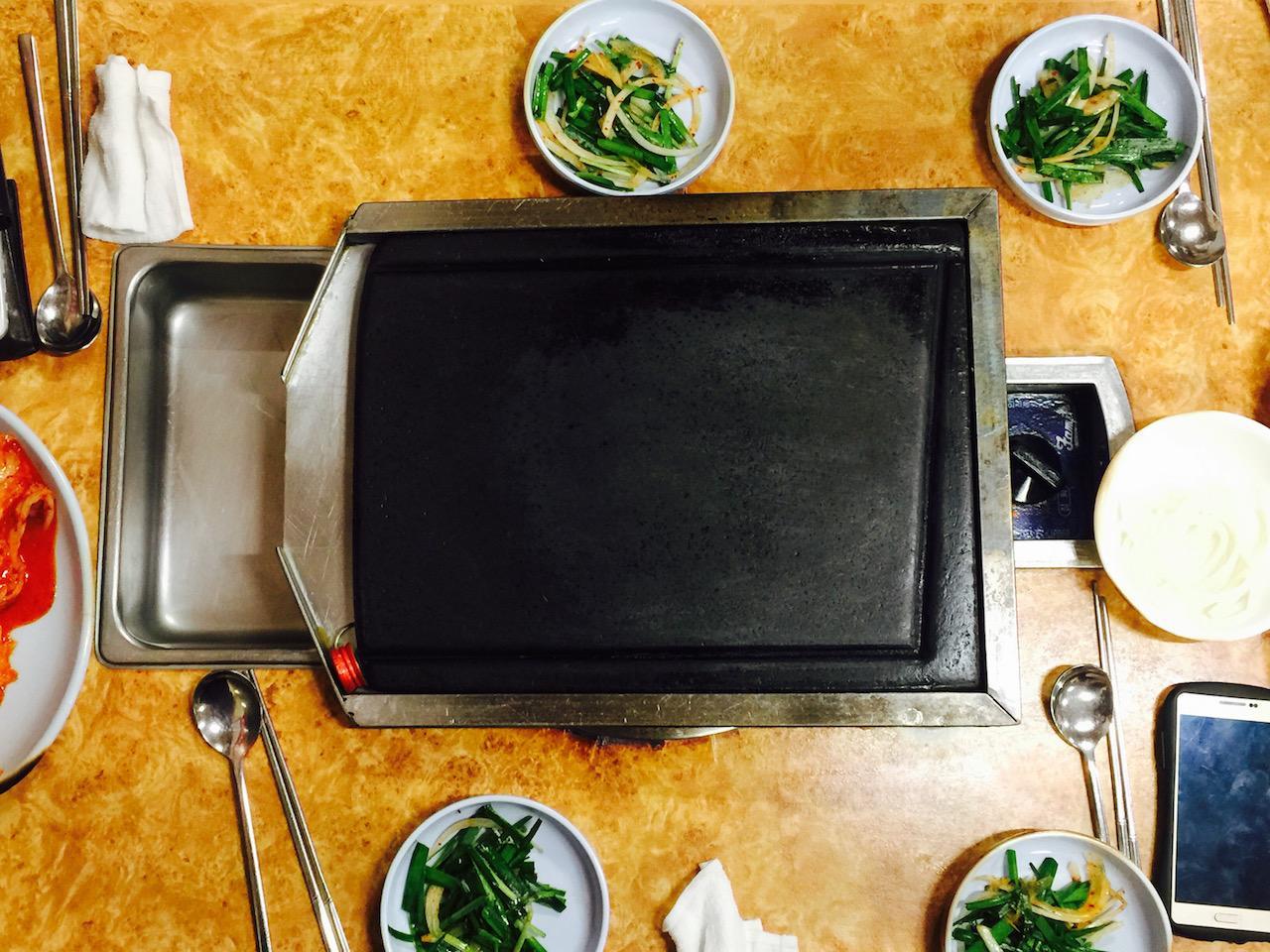 Deliciously cooked sizzling pork belly on a plate with tableware, perfect for food lovers and cooking enthusiasts.