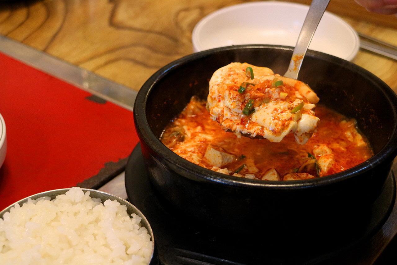 Kim Myung-ja's signature dish of hearty gukbap - a flavorful, rice-based stew accompanied by tableware and ingredients served at a restaurant in Seoul.