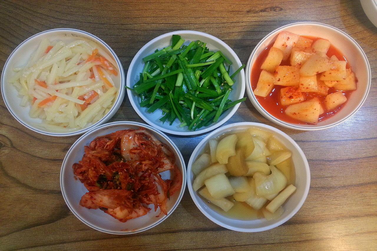 Kim Myung-ja's Gulkukbap, a Korean rice soup dish with ingredients such as vegetables and produce in a bowl on a table.