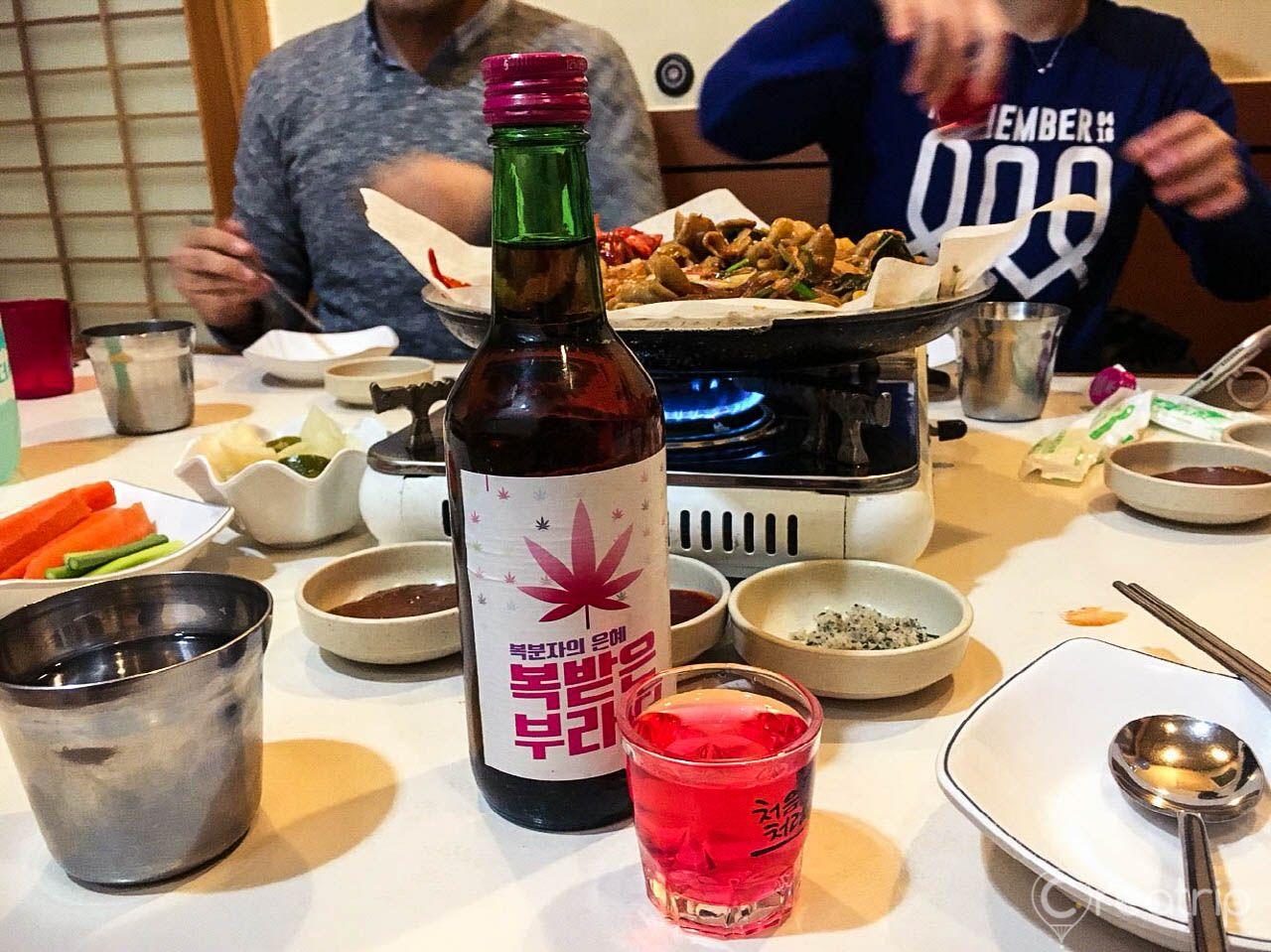 Korean cuisine spread on a table with bottles and drinkware - featuring the famous Imone Pig Intestines restaurant in Seoul.