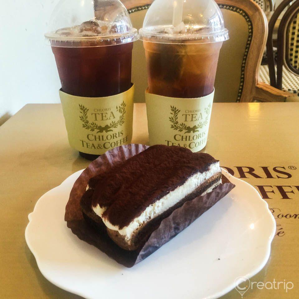 Assorted desserts and dishes displayed on table, including cake, at the Chloris Yeoksam GFC cafe in Korea.