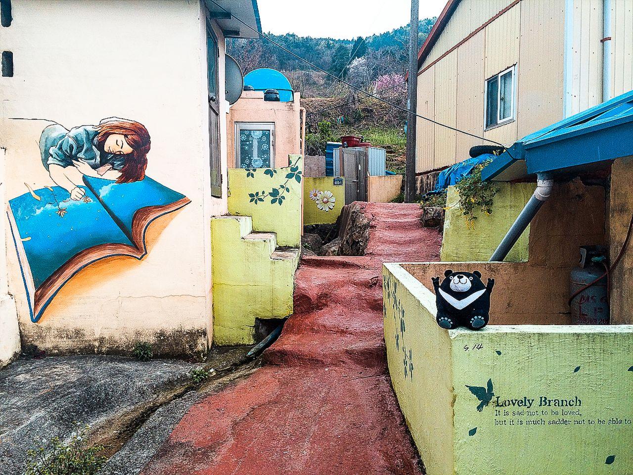 colorful buildings and houses on the blue road surface lined with plants and infrastructure in the scenic neighborhood of Gadeokdo.