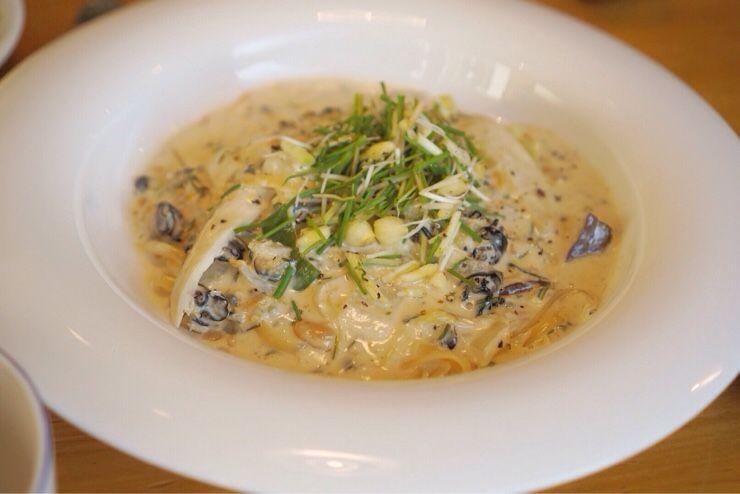 Flavorful traditional soup dish with cendol and assorted ingredients on tableware.