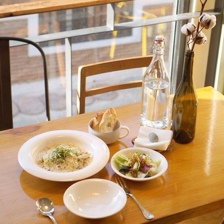 Delicious Korean pasta dish with fresh ingredients and a bottle of wine on a table in Seoul.