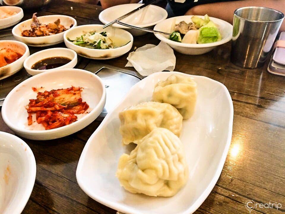 platter of Korean mandu with traditional tableware and ingredients.