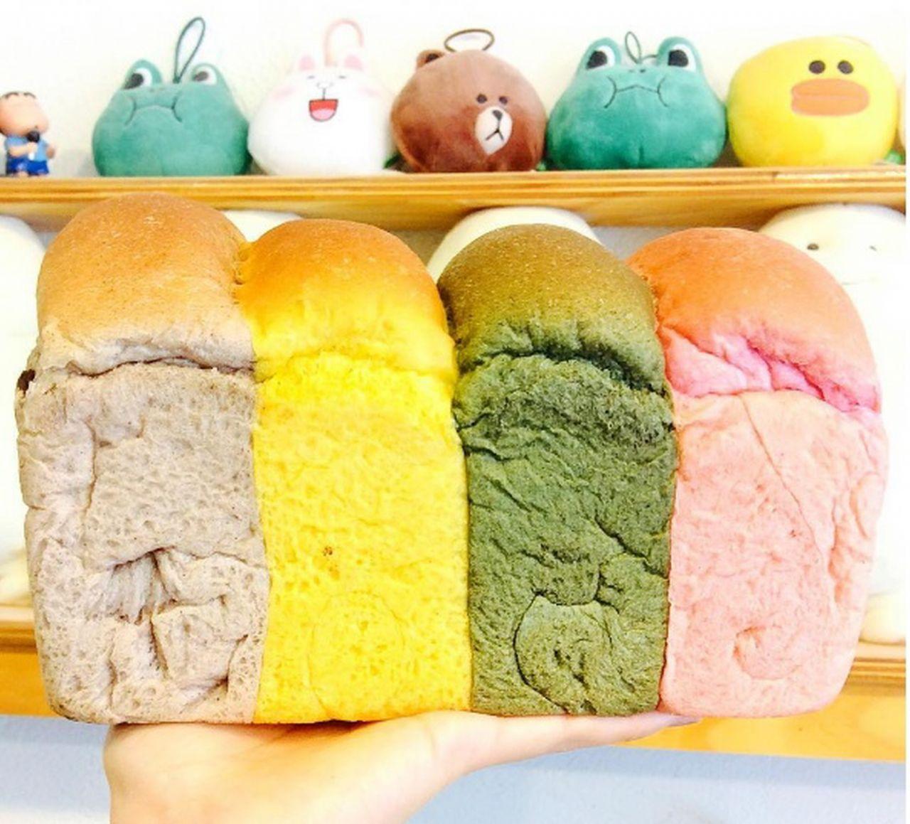 Loaf of green and blue 미소식빵 with yellow ingredients on a dish. Korean cuisine recipe.