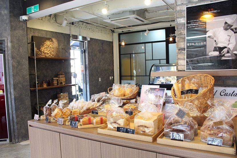 display cases of bakery and fast food items inside 카페두다트, a market and retail building in Korea with an attractive interior design.