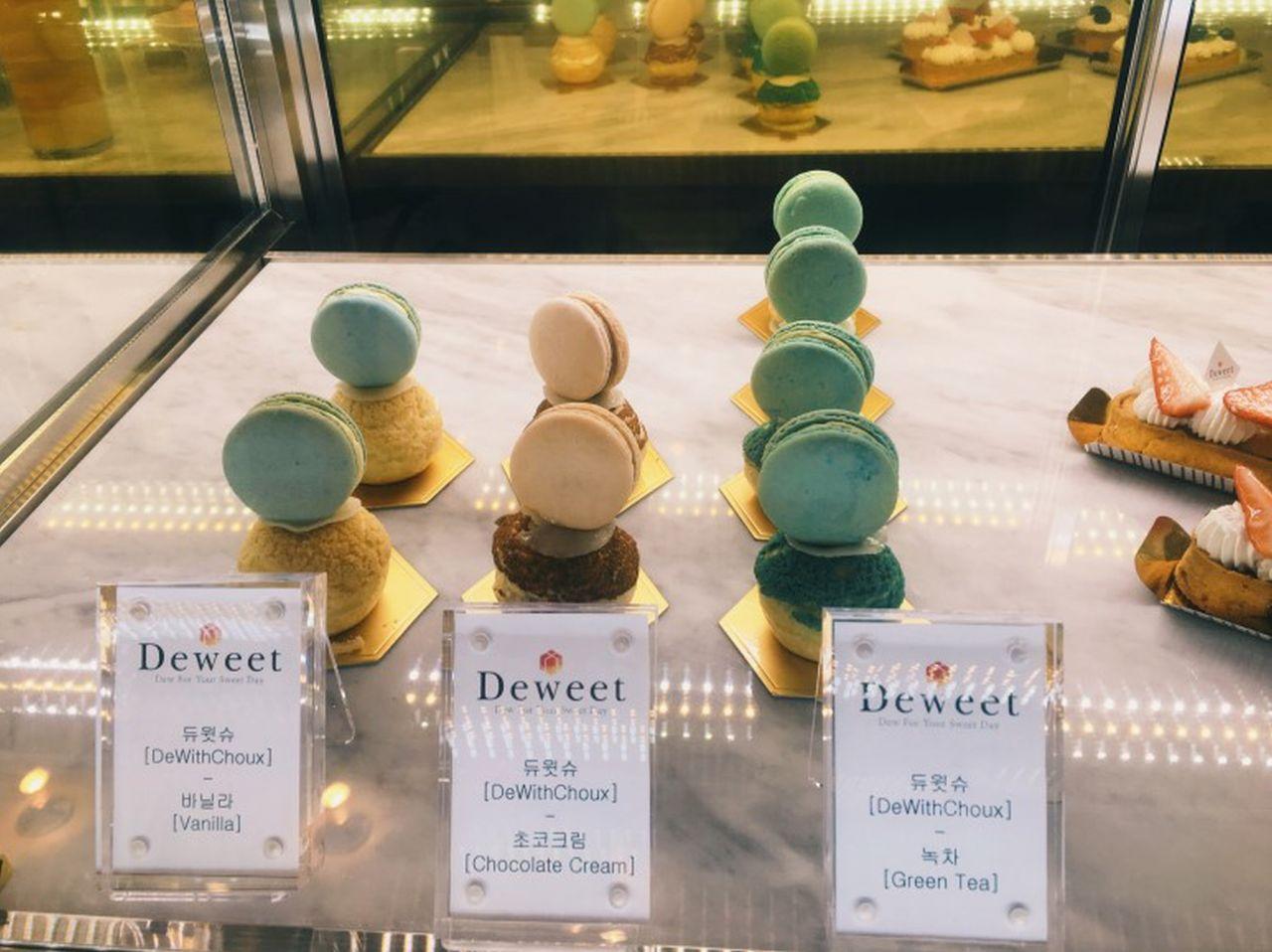 Deweet's handcrafted macarons and desserts on a table, Korean handwriting font adds a touch of fashion.