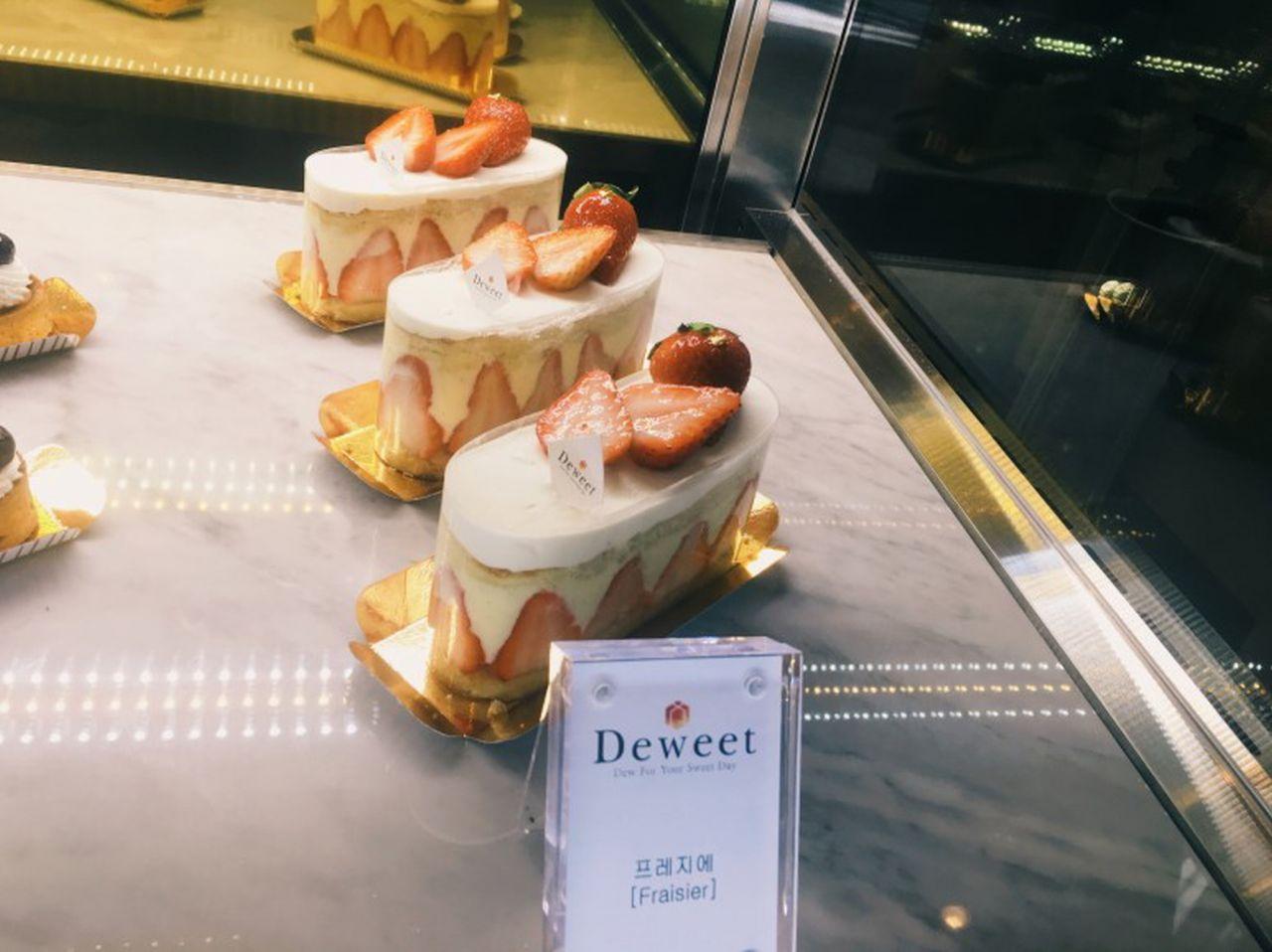 Image of beautifully decorated cakes with sugar paste and buttercream frosting displayed in a bakery's case.