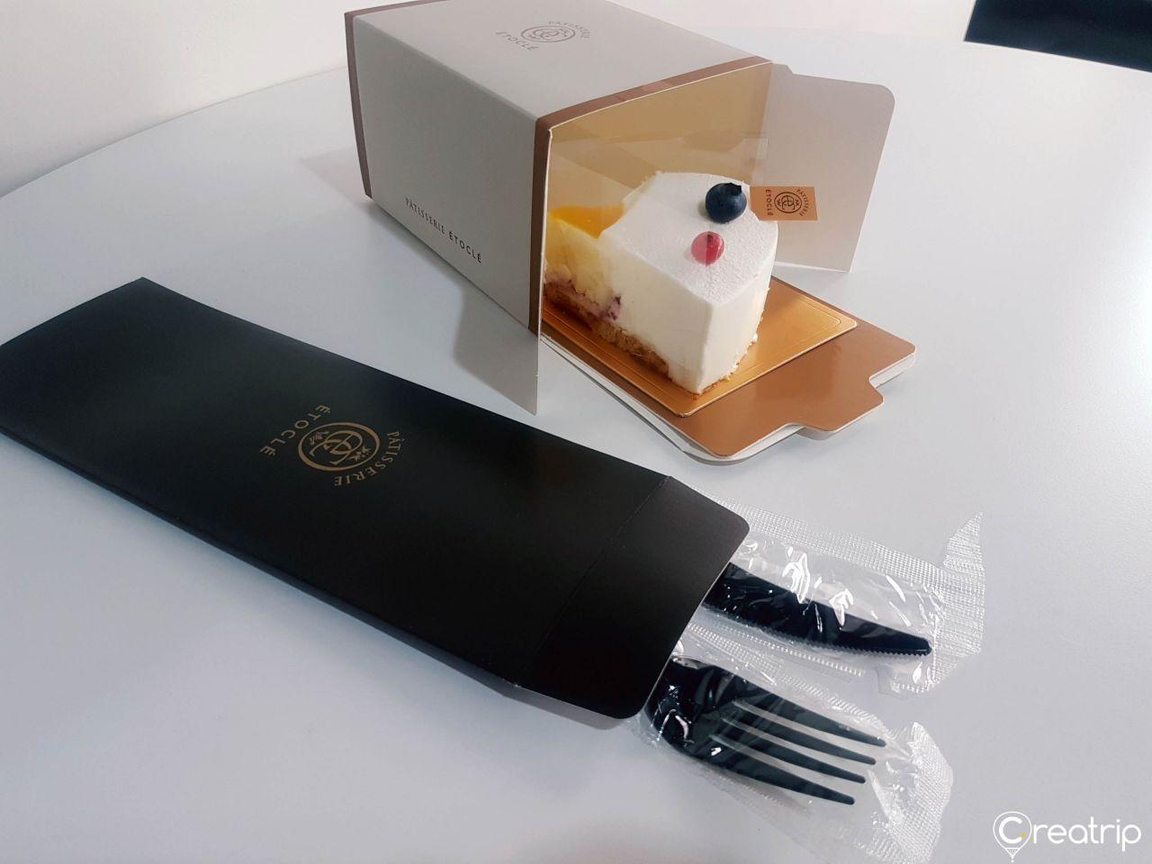 Ettokle Desserts, Cosmetics, and Office Supplies in a Rectangular Wooden Box with Electronic Devices and Writing Implements.