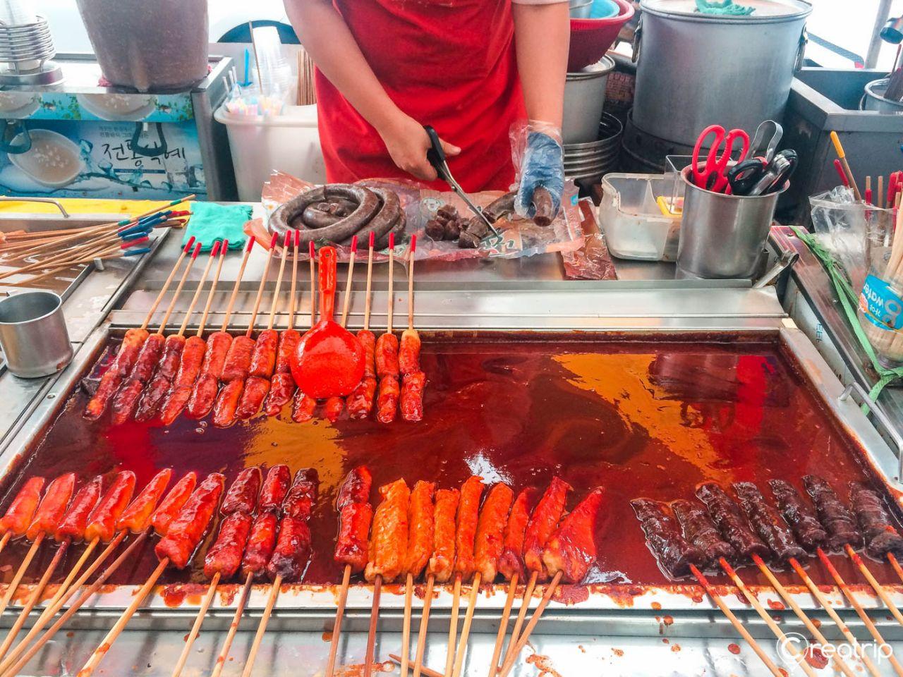 A table of Korean cuisine dishes including Suya and Satay styled with tableware and ingredients at 서문시장.